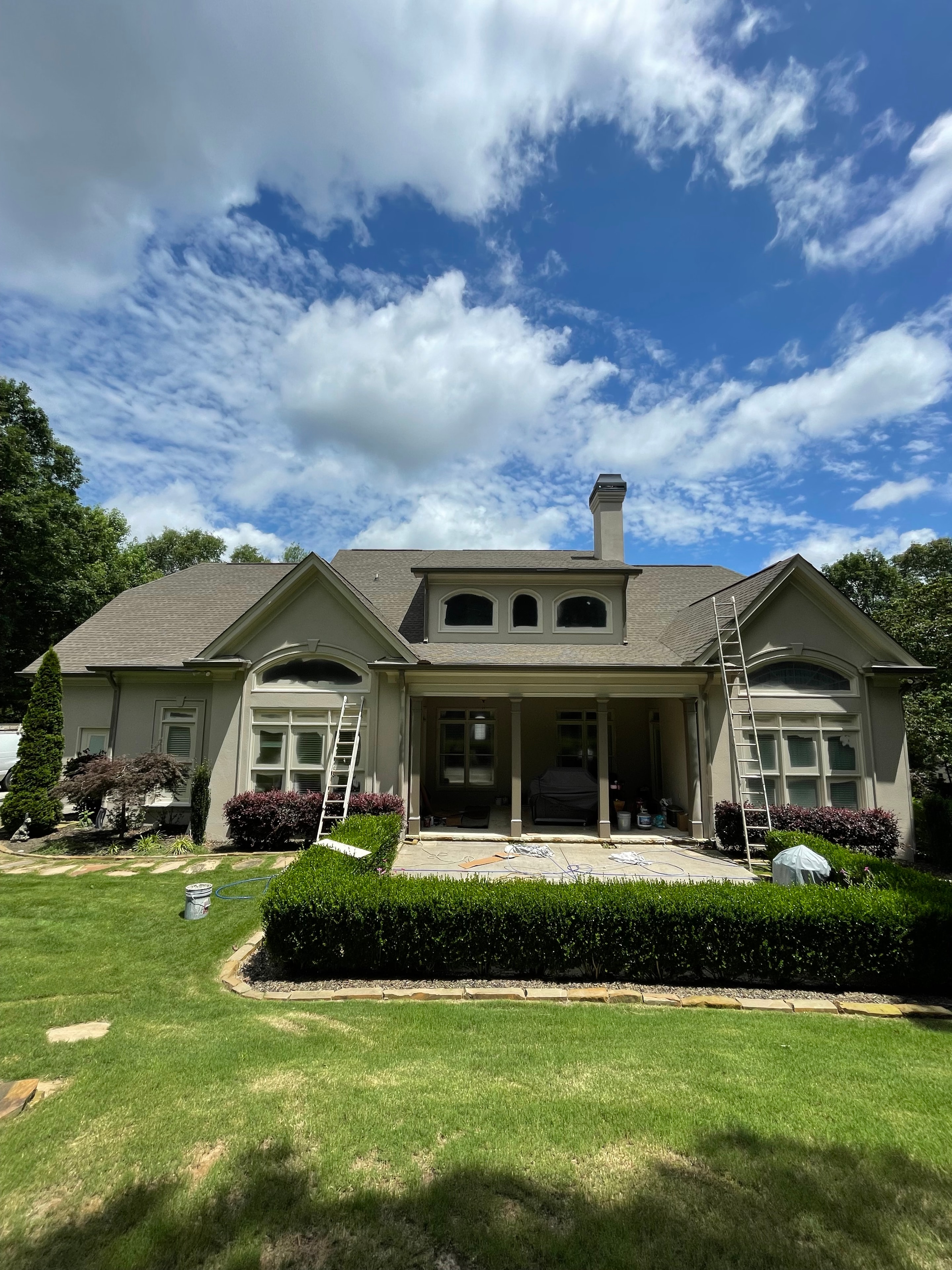 Two story home with taupe siding and white trim