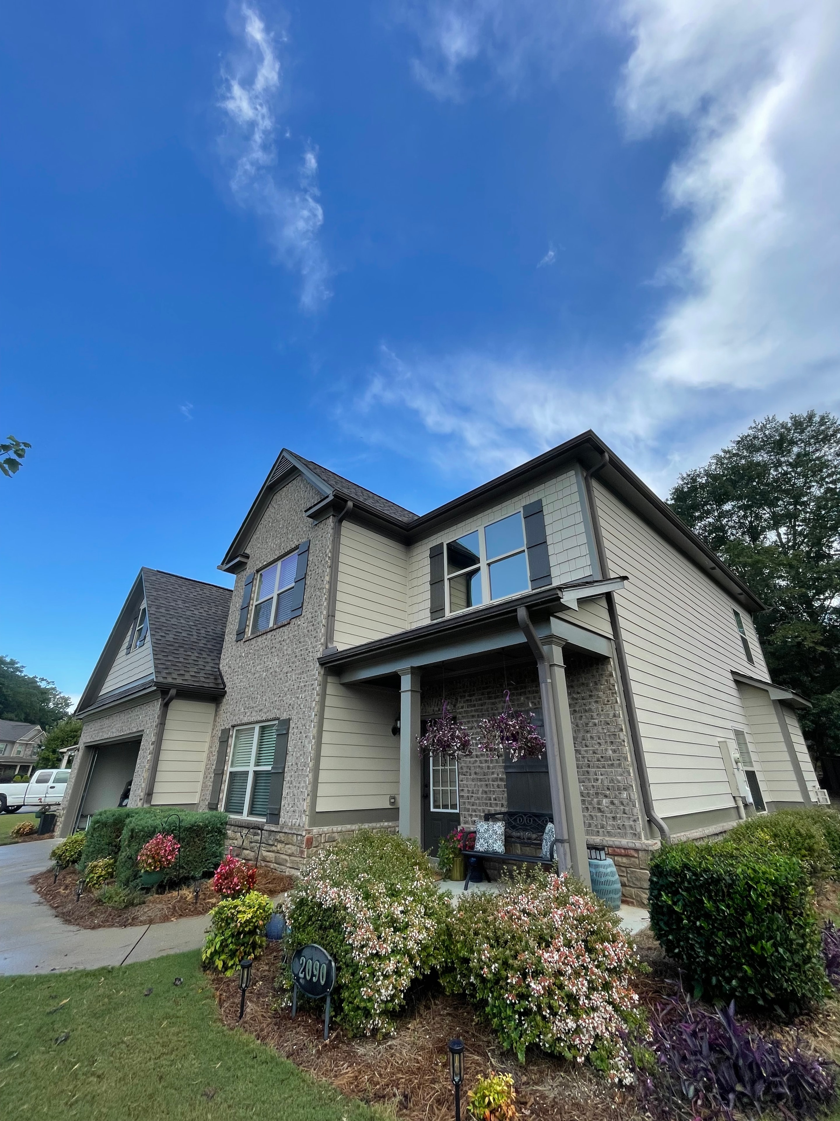 Two story home with tan siding and brick exterior